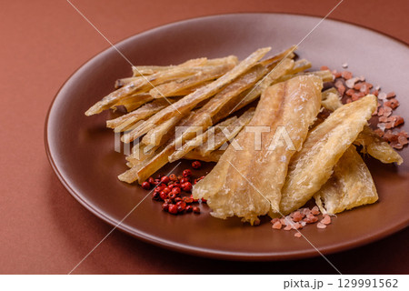 Dried salted fish, snacks or jerky, slices of white fish fillets Dried salted fish, snacks or jerky, slices of white fish fillets 129991562