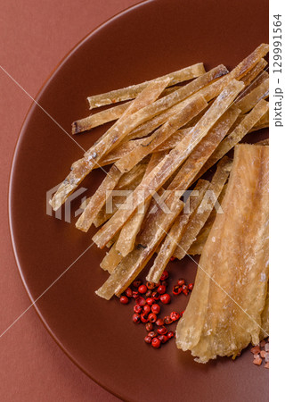 Dried salted fish, snacks or jerky, slices of white fish fillets Dried salted fish, snacks or jerky, slices of white fish fillets 129991564