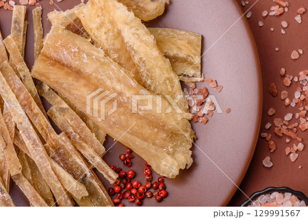 Dried salted fish, snacks or jerky, slices of white fish fillets 129991567