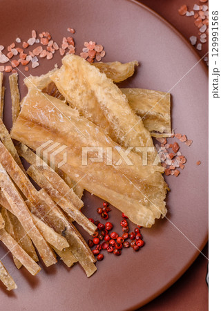 Dried salted fish, snacks or jerky, slices of white fish fillets 129991568