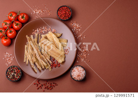 Dried salted fish, snacks or jerky, slices of white fish fillets Dried salted fish, snacks or jerky, slices of white fish fillets 129991571