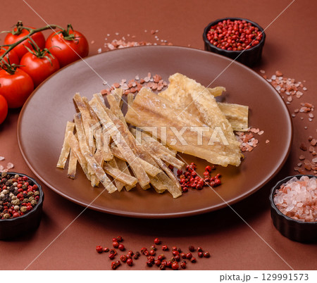 Dried salted fish, snacks or jerky, slices of white fish fillets 129991573