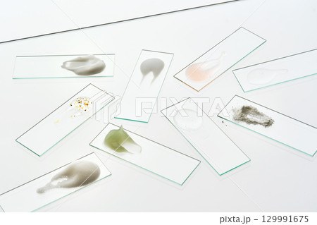 Texture samples of various cosmetic products on a gray background. Texture samples of various cosmetic products on a gray background. 129991675