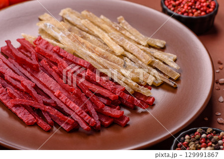 A set of jerky or snacks of chicken and fish with salt and spices 129991867