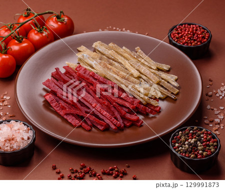 A set of jerky or snacks of chicken and fish with salt and spices 129991873