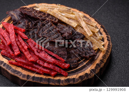 A set of jerky or snacks of beef, chicken and fish with salt and spices A set of jerky or snacks of beef, chicken and fish with salt and spices 129991908