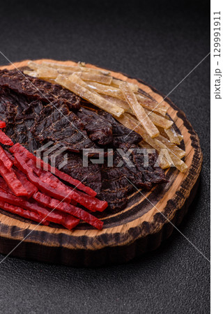 A set of jerky or snacks of beef, chicken and fish with salt and spices A set of jerky or snacks of beef, chicken and fish with salt and spices 129991911