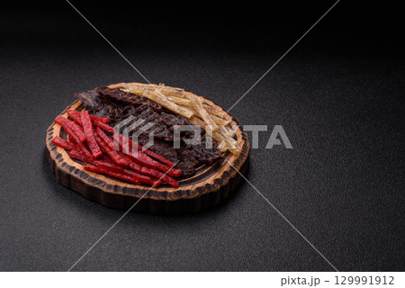 A set of jerky or snacks of beef, chicken and fish with salt and spices A set of jerky or snacks of beef, chicken and fish with salt and spices 129991912