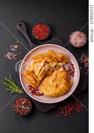 Fried French fries with a piece of meat, lunch food. Prepared potatoes and meat 129992031