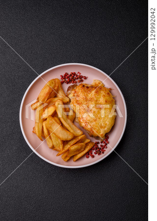 Fried French fries with a piece of meat, lunch food. Prepared potatoes and meat Fried French fries with a piece of meat, lunch food. Prepared potatoes and meat 129992042