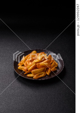 Fried crispy French fries with salt, spices, food for lunch Fried crispy French fries with salt, spices, food for lunch 129992047