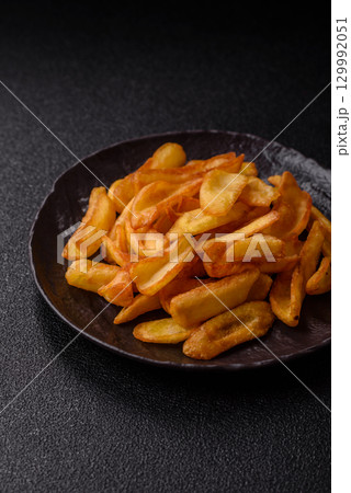 Fried crispy French fries with salt, spices, food for lunch 129992051