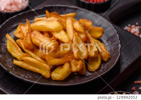 Fried crispy French fries with salt, spices, food for lunch Fried crispy French fries with salt, spices, food for lunch 129992052