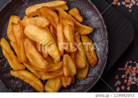Fried crispy French fries with salt, spices, food for lunch Fried crispy French fries with salt, spices, food for lunch 129992053