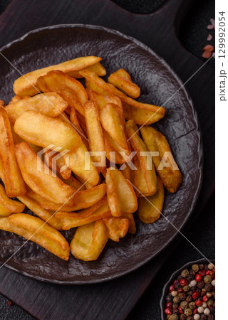 Fried crispy French fries with salt, spices, food for lunch Fried crispy French fries with salt, spices, food for lunch 129992054
