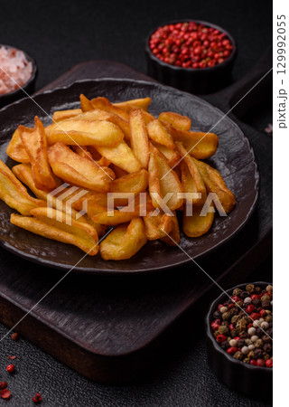 Fried crispy French fries with salt, spices, food for lunch 129992055