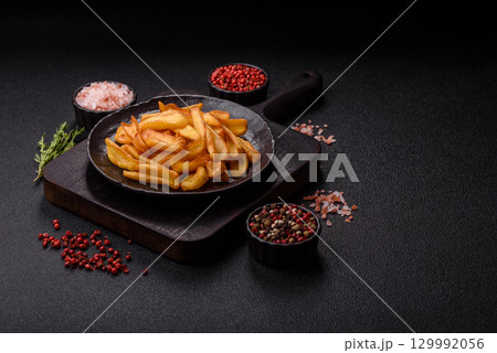 Fried crispy French fries with salt, spices, food for lunch Fried crispy French fries with salt, spices, food for lunch 129992056