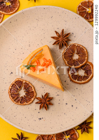 A slice of yellow cheesecake cake flavored with lemon and passion fruit 129992240