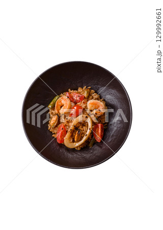 Rice and prawns or paella, a meal with seafood and vegetables. Cooked rice with shrimp Rice and prawns or paella, a meal with seafood and vegetables. Cooked rice with shrimp 129992661