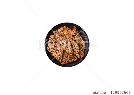Crispbread, thin bread with seeds and grains, a baked cracker. Crispbread with sesame seeds 129992668