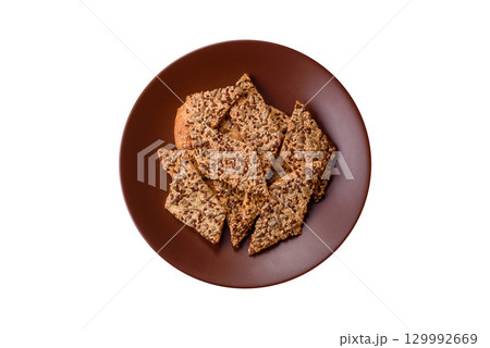 Crispbread, thin bread with seeds and grains, a baked cracker. Crispbread with sesame seeds 129992669