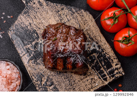 Grilled beef steak meat with salt and pepper. Beef steak grilled on a barbecue Grilled beef steak meat with salt and pepper. Beef steak grilled on a barbecue 129992846