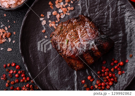 Grilled beef steak meat with salt and pepper. Beef steak grilled on a barbecue Grilled beef steak meat with salt and pepper. Beef steak grilled on a barbecue 129992862