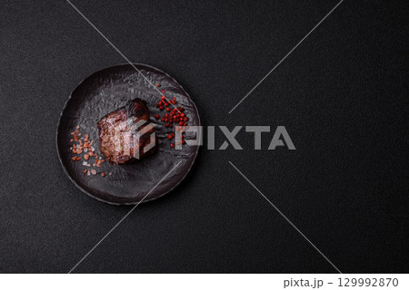 Grilled beef steak meat with salt and pepper. Beef steak grilled on a barbecue 129992870