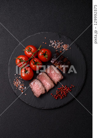 Grilled beef steak meat with salt and pepper. Beef steak grilled on a barbecue 129992875