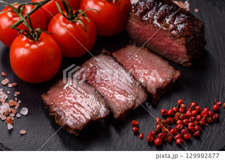 Grilled beef steak meat with salt and pepper. Beef steak grilled on a barbecue Grilled beef steak meat with salt and pepper. Beef steak grilled on a barbecue 129992877