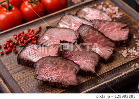 Grilled beef steak meat with salt and pepper. Beef steak grilled on a barbecue Grilled beef steak meat with salt and pepper. Beef steak grilled on a barbecue 129992893