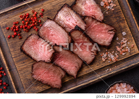 Grilled beef steak meat with salt and pepper. Beef steak grilled on a barbecue Grilled beef steak meat with salt and pepper. Beef steak grilled on a barbecue 129992894