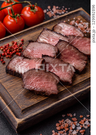 Grilled beef steak meat with salt and pepper. Beef steak grilled on a barbecue Grilled beef steak meat with salt and pepper. Beef steak grilled on a barbecue 129992896