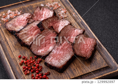 Grilled beef steak meat with salt and pepper. Beef steak grilled on a barbecue Grilled beef steak meat with salt and pepper. Beef steak grilled on a barbecue 129992897