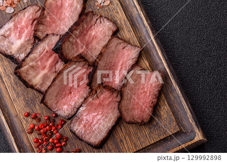 Grilled beef steak meat with salt and pepper. Beef steak grilled on a barbecue Grilled beef steak meat with salt and pepper. Beef steak grilled on a barbecue 129992898