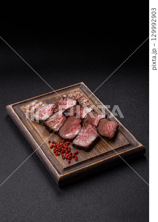 Grilled beef steak meat with salt and pepper. Beef steak grilled on a barbecue Grilled beef steak meat with salt and pepper. Beef steak grilled on a barbecue 129992903
