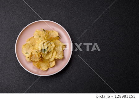 Crisps fried with salt, spices and garlic. Cooked potatoes Crisps fried with salt, spices and garlic. Cooked potatoes 129993153