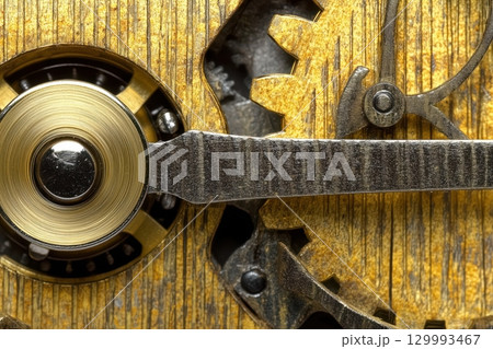 Close-up of golden gears turning inside vintage clock mechanism steampunk texture study Close-up of golden gears turning inside vintage clock mechanism steampunk texture study 129993467