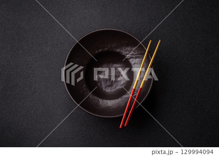 Empty round black plate for food, risotto or pasta. Empty plate on dark background Empty round black plate for food, risotto or pasta. Empty plate on dark background 129994094