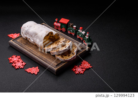 Christmas Stollen, a German sweet cake with marzipan and fruit. Winter Christmas Stollen Christmas Stollen, a German sweet cake with marzipan and fruit. Winter Christmas Stollen 129994123