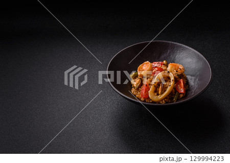 Rice and prawns or paella, a meal with seafood and vegetables. Cooked rice with shrimp Rice and prawns or paella, a meal with seafood and vegetables. Cooked rice with shrimp 129994223