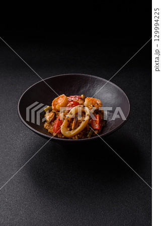 Rice and prawns or paella, a meal with seafood and vegetables. Cooked rice with shrimp 129994225