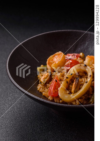 Rice and prawns or paella, a meal with seafood and vegetables. Cooked rice with shrimp Rice and prawns or paella, a meal with seafood and vegetables. Cooked rice with shrimp 129994228