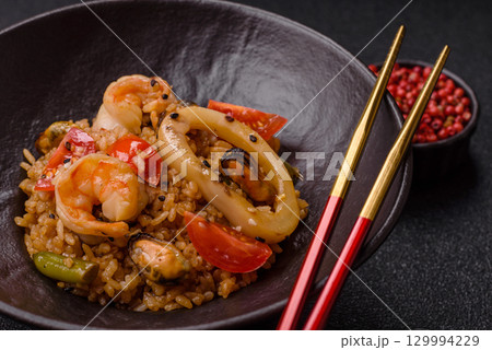 Rice and prawns or paella, a meal with seafood and vegetables. Cooked rice with shrimp Rice and prawns or paella, a meal with seafood and vegetables. Cooked rice with shrimp 129994229