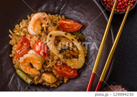 Rice and prawns or paella, a meal with seafood and vegetables. Cooked rice with shrimp Rice and prawns or paella, a meal with seafood and vegetables. Cooked rice with shrimp 129994230