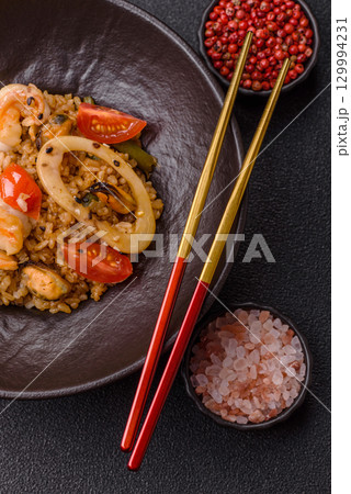 Rice and prawns or paella, a meal with seafood and vegetables. Cooked rice with shrimp 129994231