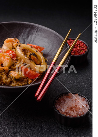 Rice and prawns or paella, a meal with seafood and vegetables. Cooked rice with shrimp 129994232