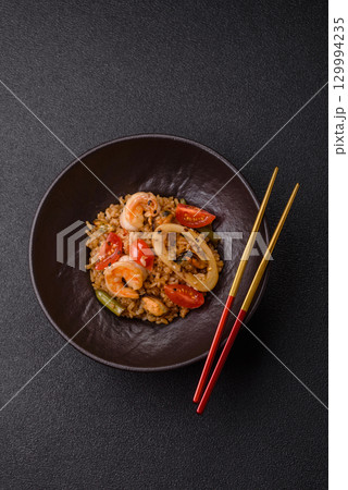 Rice and prawns or paella, a meal with seafood and vegetables. Cooked rice with shrimp Rice and prawns or paella, a meal with seafood and vegetables. Cooked rice with shrimp 129994235