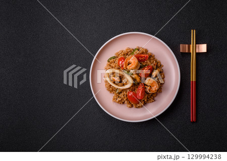 Rice and prawns or paella, a meal with seafood and vegetables. Cooked rice with shrimp 129994238