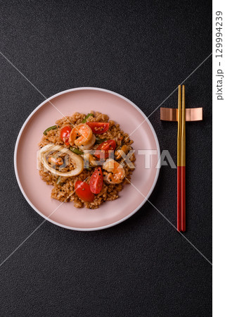 Rice and prawns or paella, a meal with seafood and vegetables. Cooked rice with shrimp 129994239